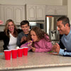 Minute to win it family game night ideas. Family of all ages shown playing a game with red solo cups and ping pong balls having lots of fun.