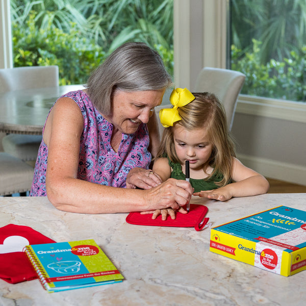 Grandma and grandchild Personalizing a potholder, included in Little Bridges activity kits.